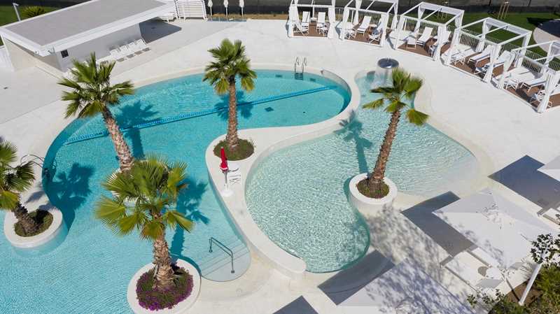 Tropisch zwembad omringd door palmbomen